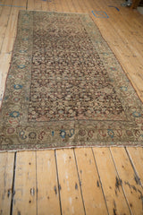 Antique Persian Malayer runner's full length showing a dense Herati design and palmette border.