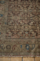 Detailed corner view of a tea-washed Malayer rug with its Herati field and complex boteh border.