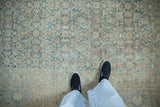 Distressed vintage Meshed rug detail showing faded Herati design in muted blue and cream.