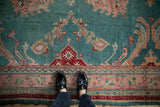 Vintage Oushak carpet border detail with dusty rose, red, and jade green palmettes.