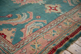 Vintage Oushak carpet's jade green field with large-scale scrolling plants and blush border.