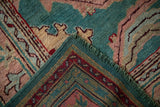 Turkish Oushak rug corner reveals patterned jade green pile and woven back.