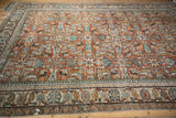 Vintage Mahal rug showing Herati floral palmettes and border vinery in rust, blue, ivory.