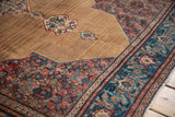 Angled view of an antique Senneh corner with camel field abrashes and intricate Herati border.