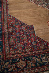 Corner detail of a fine Senneh rug showing the wool pile and abrashes on the camel brown field.