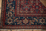 Herati motifs in the sapphire blue border and red corner spandrel of an antique Persian Senneh rug.