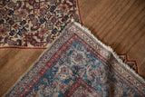 A corner of the antique Senneh rug showing the fine pile front and the camel brown hand-knotted back.