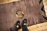 A top-down view of the antique Peking rug showing the low pile texture and mauve field.
