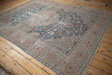 Distressed Farahan Sarouk rug border with intricate dusty rose, beige, and blue floral motifs.