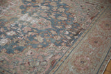 Vintage Distressed Farahan Sarouk carpet's worn floral patterns in dusty blue and blush tones.