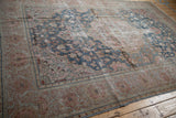 Distressed outer border of the Farahan Sarouk rug with dusty rose and sand floral motifs.