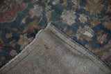 Distressed dusty blue and rose floral pile on a hand-knotted Farahan Sarouk foundation.