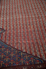 Antique Qashqai runner detail: repeating vinery columns, madder red field, and sapphire blue corner spandrel.