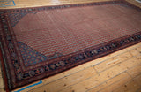 Antique Qashqai rug corner showing sapphire blue lattice spandrel and floral vinery border.
