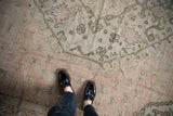 Vintage Oushak carpet's muted rose field with olive green arabesques and soft, varied pile.