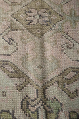 Hand-knotted vintage Oushak rug pile with dusty rose, muted bronze, and charcoal motifs.