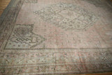 Vintage Oushak rug corner showing outer minor borders with repeating trellis pattern in dusty rose.