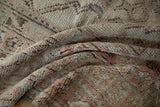 Varied pile texture and knot heads on a hand-knotted rug, dusty rose and muted green.