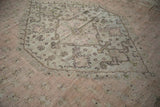 Detail of vintage Oushak showing dusty rose field, oxidized silver floral arabesques, and scrolled tendrils.