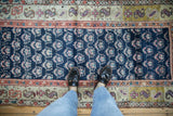 Cobalt blue field with germinating plant pattern on an antique Kurd runner, terracotta border.