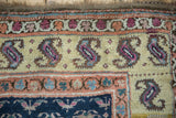 Kurd rug corner featuring stylized plant and bird motifs in terracotta, ivory, and cobalt blue.