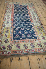 Antique Kurd rug's ivory and saffron border with vibrant paisley, cobalt blue field of germinating plants.