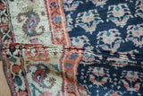 Folded hand-knotted pile of antique Kurd runner, revealing cobalt blue, ivory and terracotta motifs.