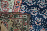 Folded antique Kurd runner detail, showing varied pile texture and rich blue, ivory, terracotta plant motifs.