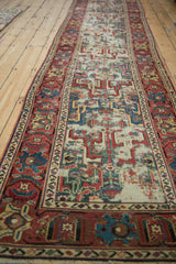 Antique Caucasian runner detail, geometric arabesques field, raspberry red border, visible foundation wear.