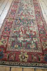 Close-up of worn fringe and geometric Herati border on antique Caucasian rug.