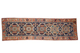 Vintage Karaja hand-knotted runner featuring repeating geometric medallions in navy blue and rust, 3'3