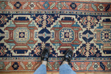 Karaja runner's central medallion and serrated leaves in navy, rust, sky blue with feet.