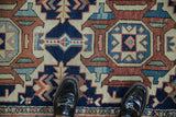 Vintage Karaja rug detail: navy, terracotta, sky blue geometric pattern and serrated leaves.