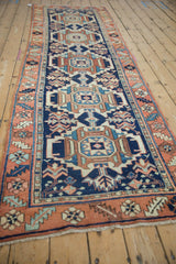 Navy and terracotta repeating geometric medallions with serrated leaves on a Karaja runner.