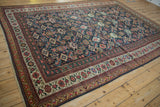 Antique Mahal carpet's madder red and ivory borders frame a rich navy Herati field.