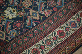 Navy Herati field meets intricate madder root red, green, ivory border on this Antique Mahal carpet.