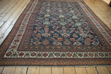 Detail of antique Mahal carpet's vibrant Herati field, madder red borders, and fringe.
