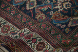 Intricate Herati pattern and border detail on a Persian Mahal carpet in vivid navy, red.