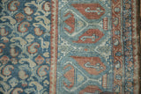 Distressed vintage Malayer rug detail, showing teal boteh field and geometric border.