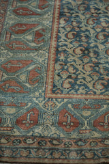 Distressed terracotta geometric border meets blue boteh pattern on vintage Malayer rug.