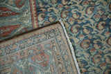 Distressed vintage Malayer rug corner shows teal, terracotta pattern, even pile wear, and hand-knotted fringe.