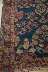 Antique Mohajeran Sarouk runner: side border detail with raspberry red, gold vines, and edge tatter.