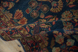 Antique Mohajeran Sarouk pile showing bell flowers, pinwheel motifs, and serrated leaves on cobalt blue.