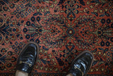 Allover dusty rose and navy floral motifs on a hand-knotted German Sarouk rug.