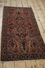 Vintage Sarouk rug runner with terracotta floral field, navy vased plant motifs, and patterned side border.