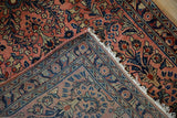 Hand-knotted Vintage Sarouk rug showing dusty rose floral pile and intricate woven foundation.
