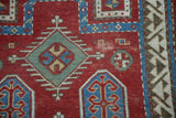 Low pile texture and geometric medallions on a cherry red antique Fachralo Kazak rug.