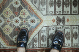 Distressed vintage Malayer runner with alternating floral quatrefoil and geometric field patterns in muted colors.