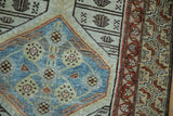 Vintage Malayer rug: distressed field with sky blue floral quatrefoil and rust border.