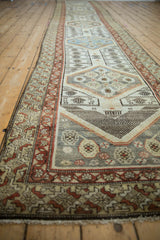 Distressed Malayer runner featuring time-softened ivory, rust, and sky blue floral motifs.